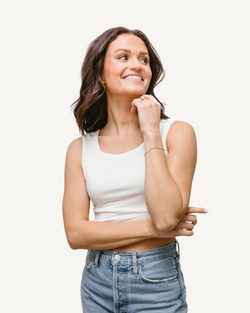 A woman wearing an Elegant Tank, seen from the back, in a white crop top.