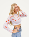 A white crop top featuring a red heart print, designed by HALFTEE Layering Fashions for a trendy layered look.