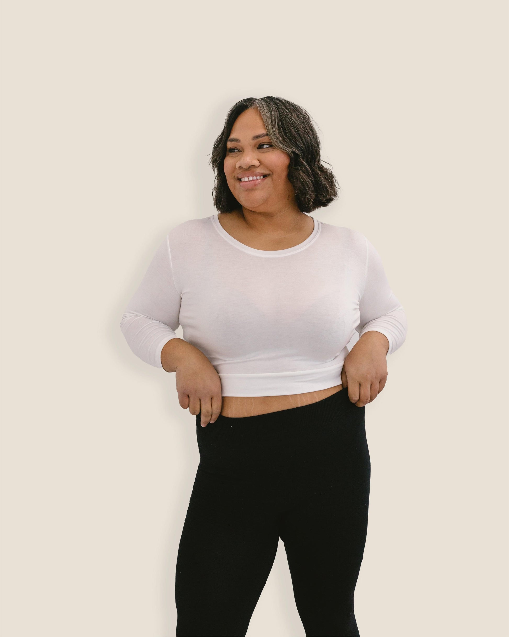 A woman in a white crop top and jeans, wearing a Crew Neck 3/4 Sleeve Halftee.