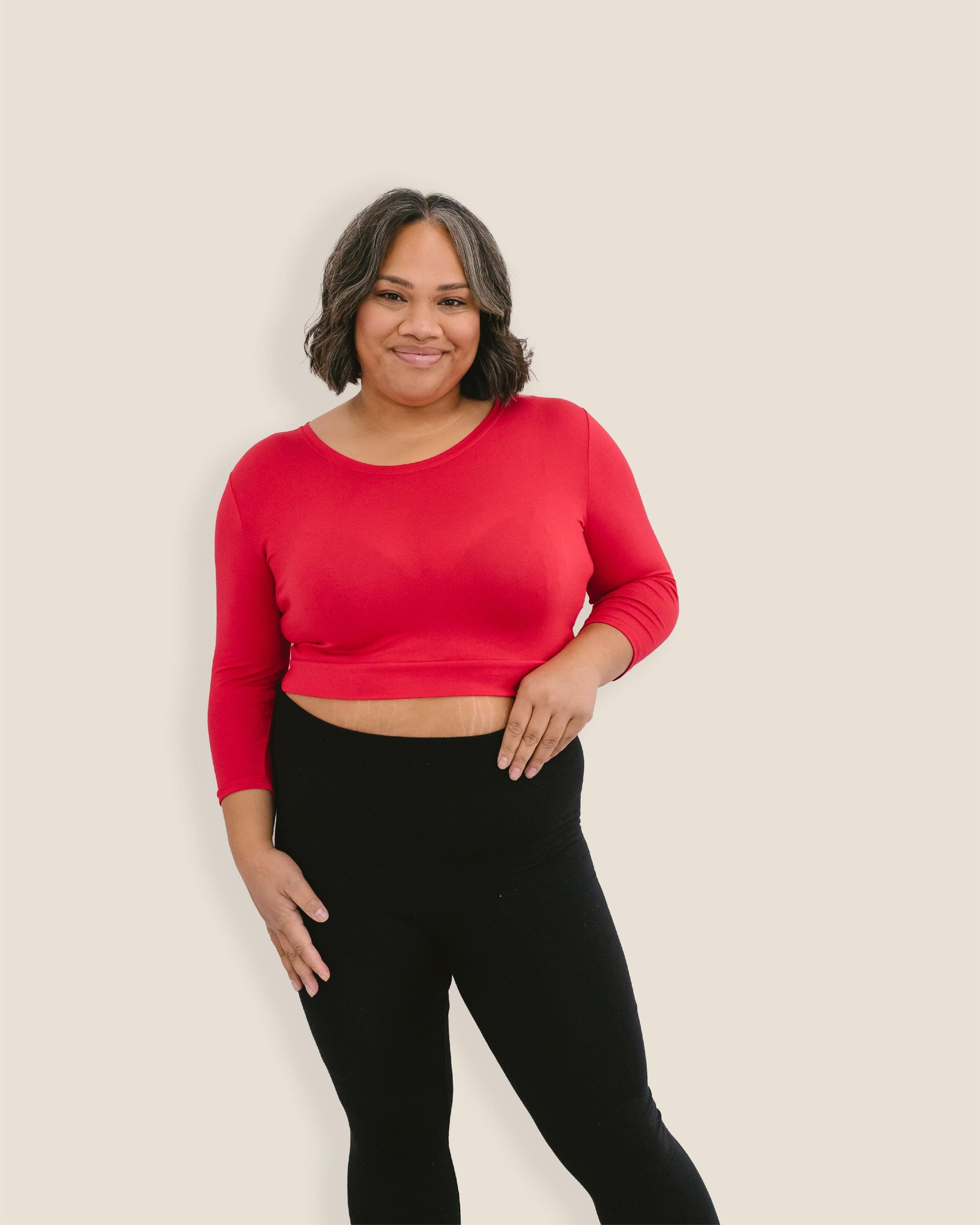 A woman in a red crop top and jeans, wearing a Crew Neck 3/4 Sleeve Halftee.