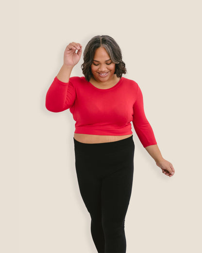 A woman in a red crop top and jeans, wearing a Crew Neck 3/4 Sleeve Halftee.