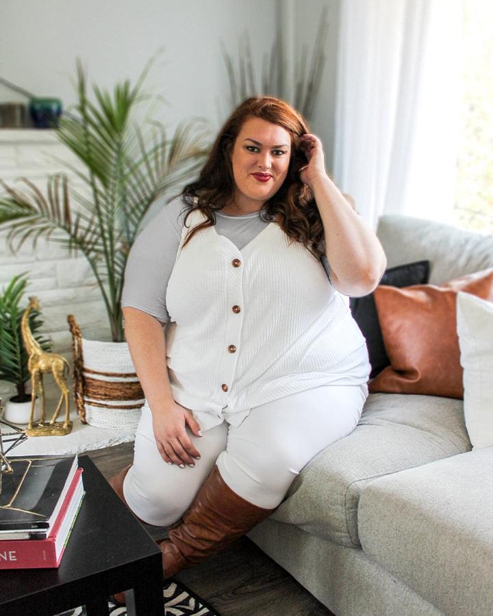 A woman wearing a gray crew neck elbow sleeve top and white shirt and pants.