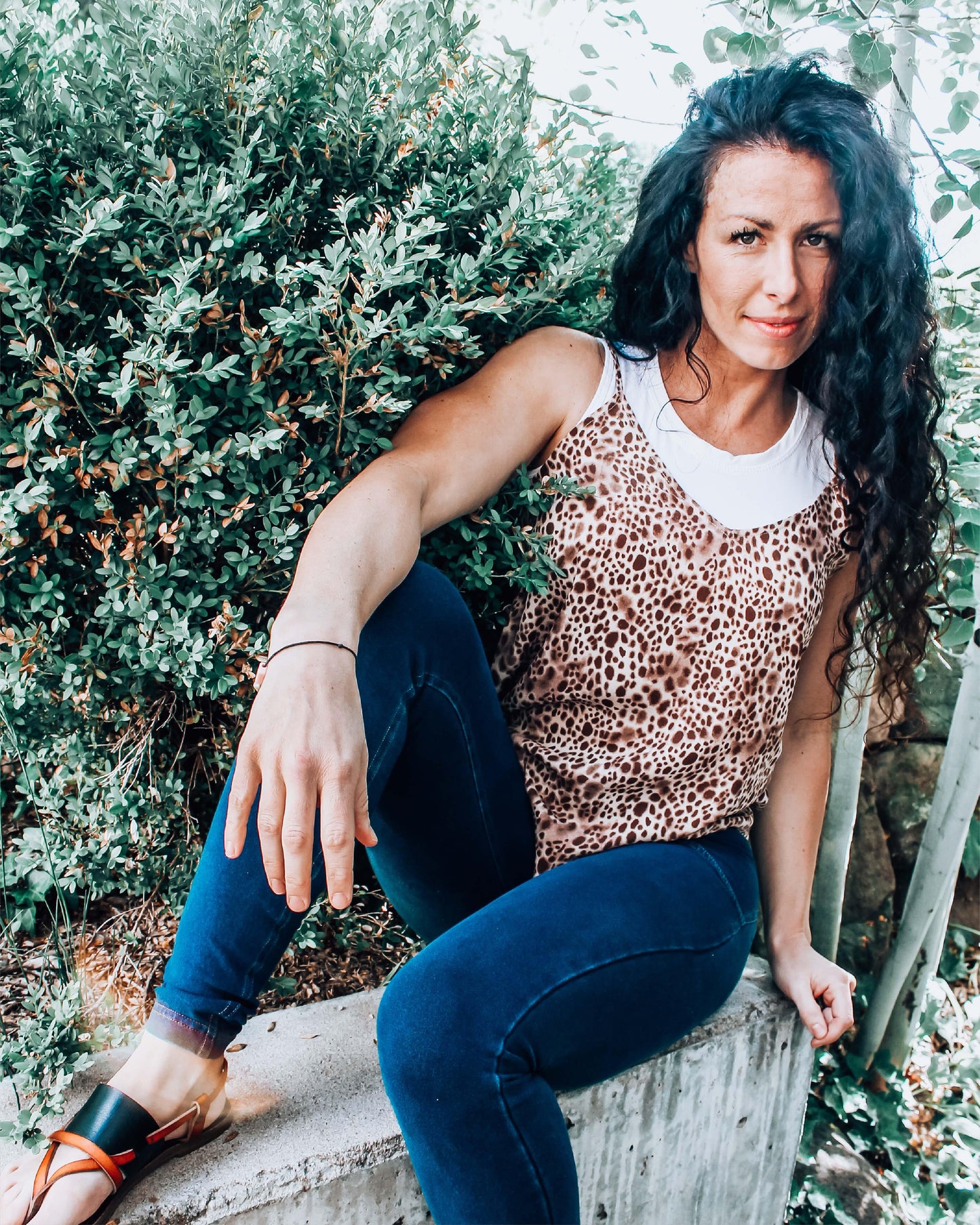 A woman wearing a white crop top and jeans, paired with a Crew Neck Tank Halftee.