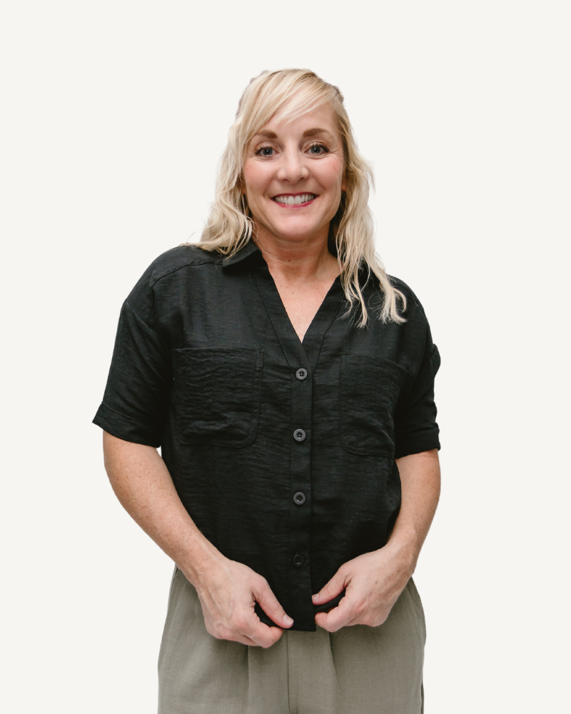 A woman wearing gray pants and a linen-look short sleeve button-down shirt.