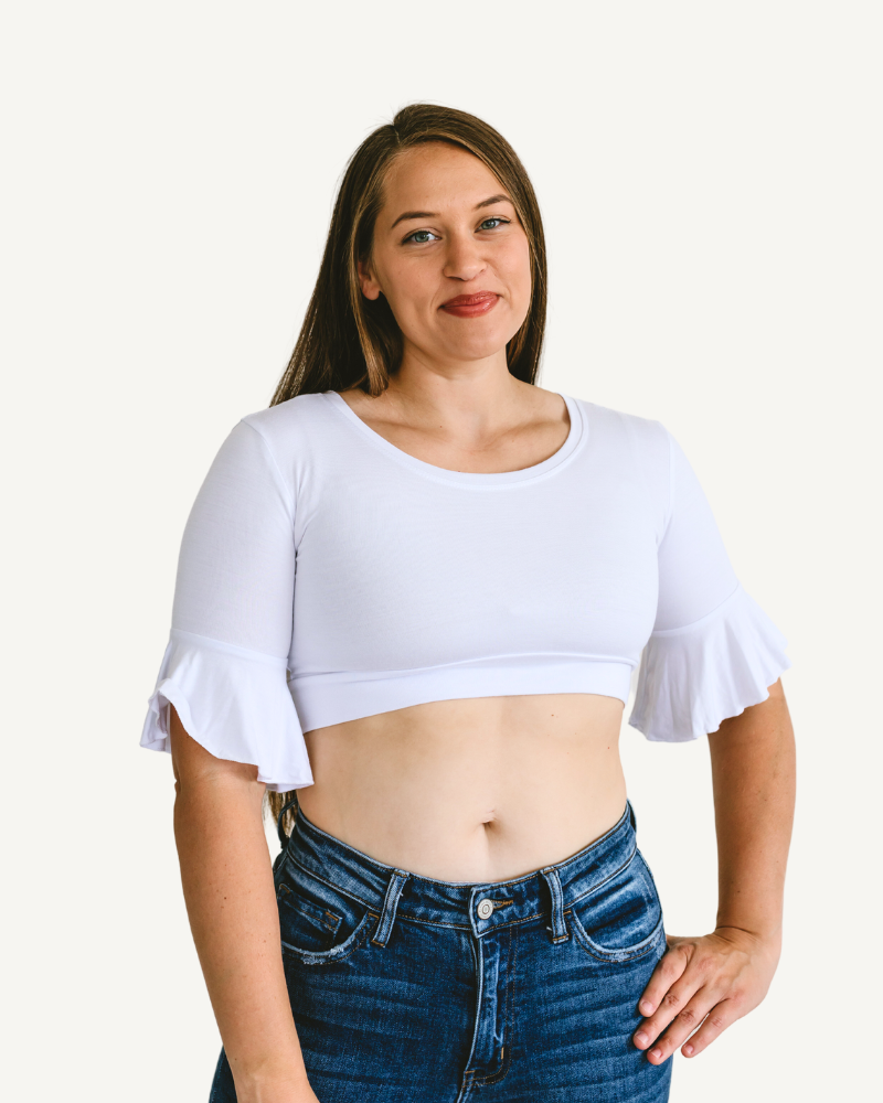 A woman wearing a white crop top and jeans, showcasing a Bell Sleeve Halftee.