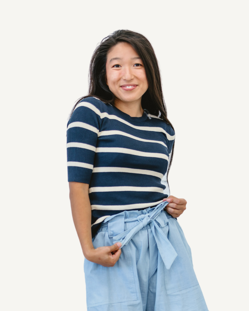 A woman wearing blue shorts and a Striped 3/4 Ribbed Sleeve Sweater in blue.