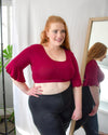 Woman in red top and black leggings, wearing a Bell Sleeve Halftee.