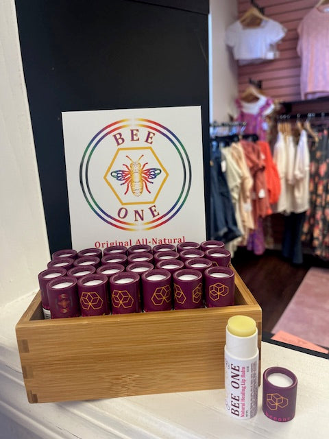 A display of Bee One Natural Healing Lip Balm and other items on a counter.