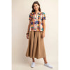 A model showcases a vibrant multi-colored shirt paired with stylish wide-leg pants, exuding a trendy and relaxed vibe.