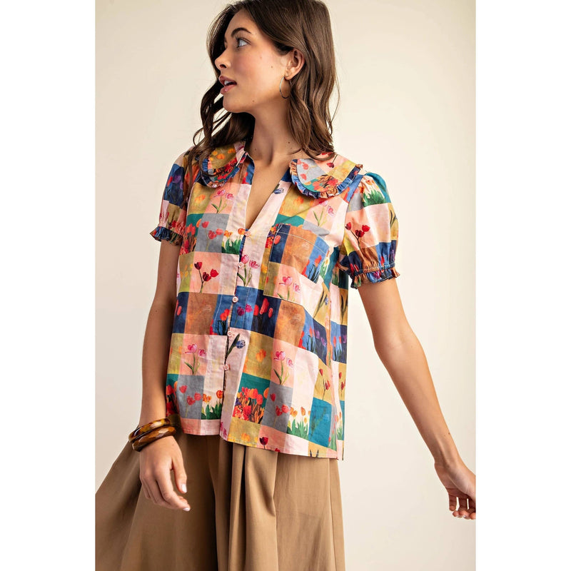 A model presents a lively, multi-hued shirt teamed with fashionable wide-leg pants, radiating a trendy and laid-back atmosphere.