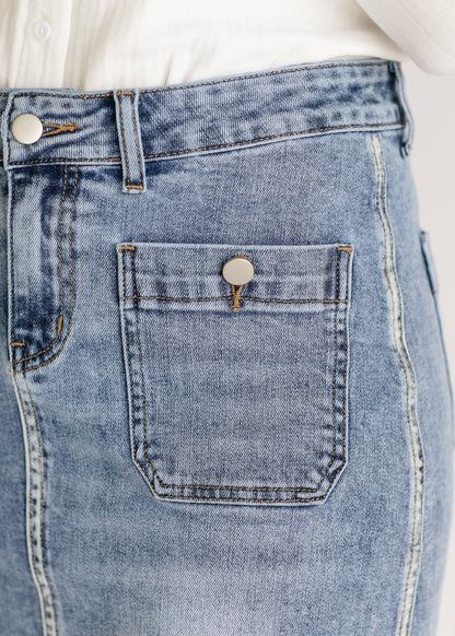 Close-up of light blue denim jeans showing a metal button on the front pocket. The jeans are paired with a white shirt. Casual and classic style.