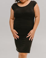 Woman wearing a black Halftee layering top with a fitted design.