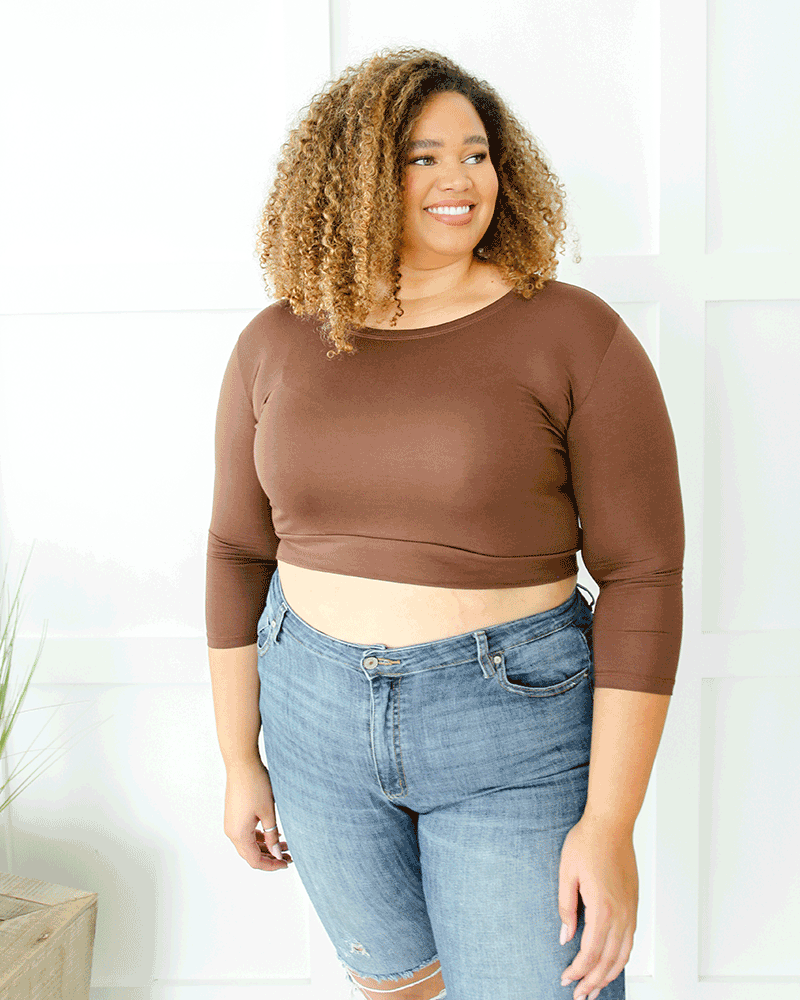 A woman in a brown  crop top and jeans, wearing a Crew Neck 3/4 Sleeve Halftee.