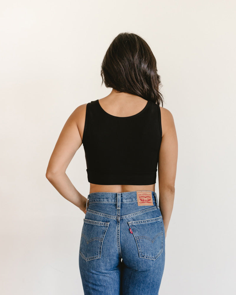 woman in a black crop top and jeans, wearing a Peekaboo Short Sleeve Halftee with lace inset.