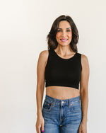 woman in a black crop top and jeans, wearing a Peekaboo Short Sleeve Halftee with lace inset.