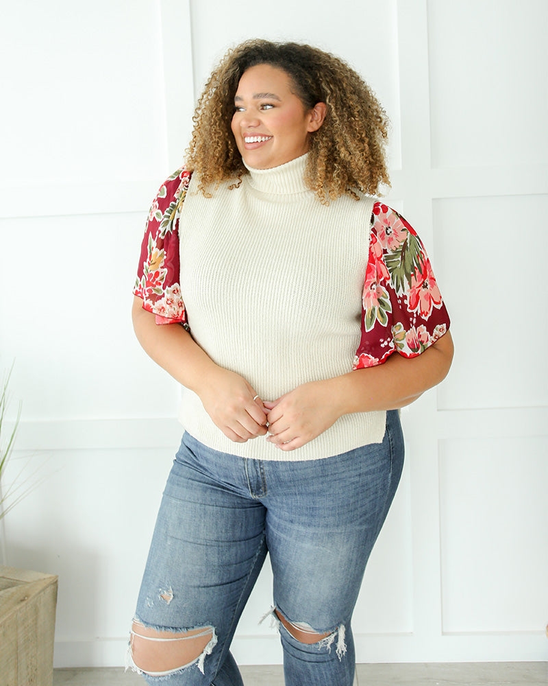A plus size woman wearing an ivory floral sleeve top.