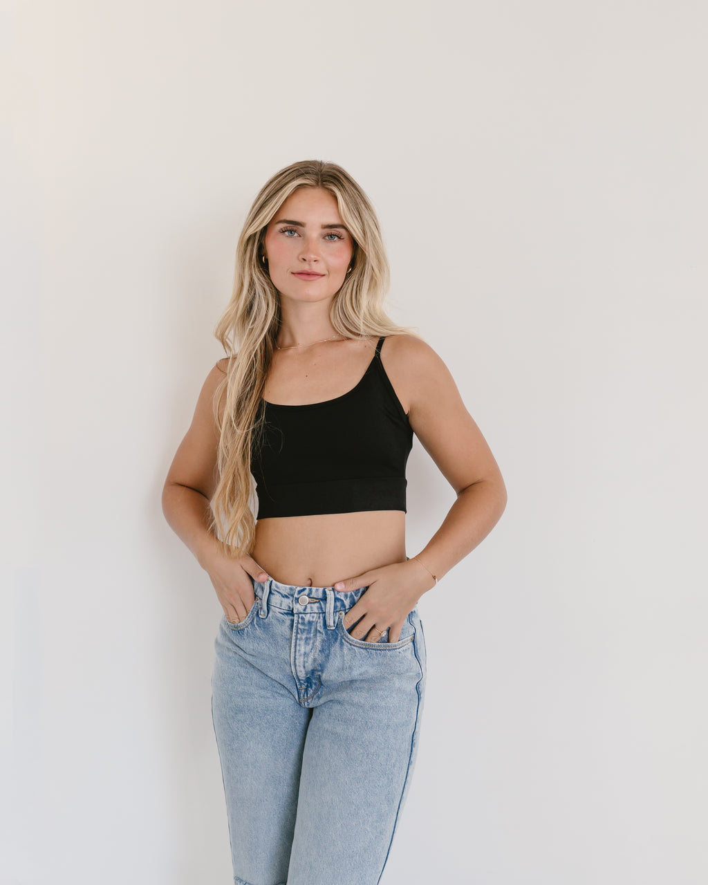 Woman in jeans and black crop top, wearing Spaghetti Strap Halftee.