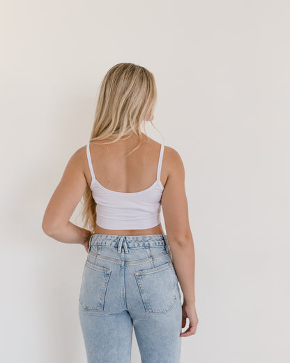 Woman in jeans and black crop top, wearing white Spaghetti Strap Halftee.